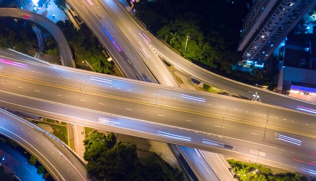 Una impresionante vista a&eacute;rea captura el vibrante ritmo de una bulliciosa autopista nocturna, con filas de deslumbrantes veh&iacute;culos circulando a toda velocidad,