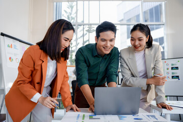Group of joyful business partners engaging in discussions and strategizing work plans in a modern...