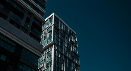 Fototapeta premium Geometric Cityscape Two Modern Buildings Against Dark Sky