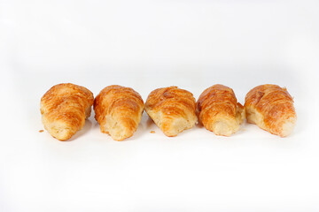 Several mini croissants neatly arranged on a white background