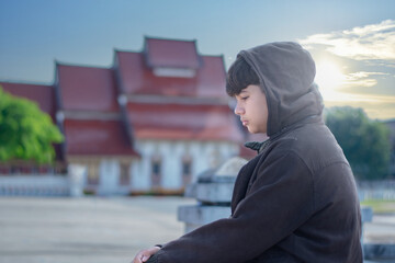 Portrait of young asian boy who has broken family, homeless, living, sitting and standing in front...