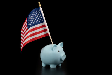 Blue piggy bank and US flag on black background