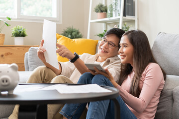 financial in family concept, Happy Asian husband and wife calculating income and bills to plan for...