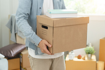 People relocation move home concept, Man carrying belongings box moving in new apartment.