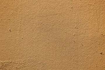 Photograph of rough textured brown cement wall. Concept: Textures, rough, construction.