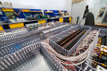 Electrical cabinet containing relays and wires connecting to a control panel
