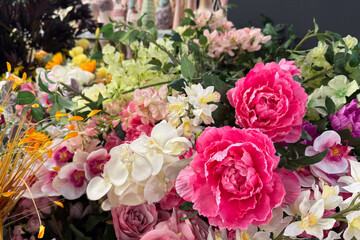 artificial flowers in shades of pink, white, and yellow is arranged in a lush and colorful display