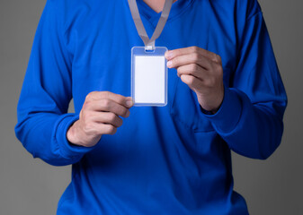 man holding id tag on brown background