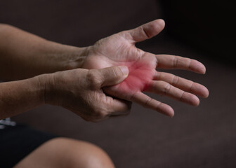 Trigger Finger, Senior woman's left hand massaging her ring finger, Suffering from pain, Close up and macro shot, Health care concept