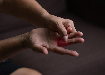 Trigger Finger, Senior woman's left hand massaging her ring finger, Suffering from pain, Close up...