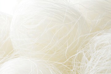 Fototapeta premium Close-up of a large quantity of delicate, white, tangled noodles. A close look at the texture, showing their thin, almost thread-like strands
