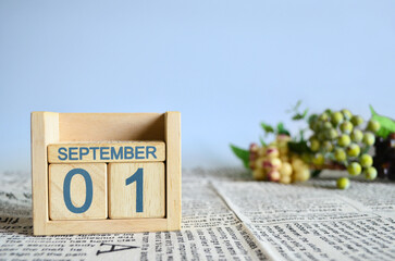 September 1, Calendar cover design with number cube with fruit on newspaper fabric and blue background.	