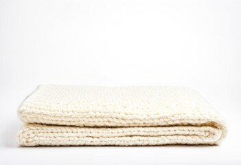 A white blanket folded on top of a white surface.