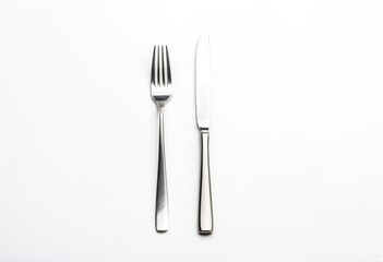 A knife, fork and spoon on a white surface.