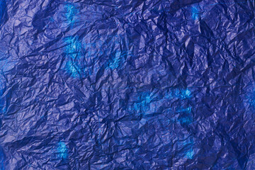crumpled used blue carbon paper surface background, navy blue tone waxy or oily wrinkled thin sheet in full frame, textured backdrop of copy space