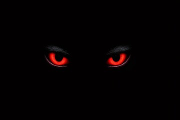 Glowing red eyes piercing through the darkness, creating a chilling and eerie ambiance filled with fear and sinister mystery