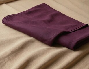 Elegant burgundy fabric draped over a soft beige background, showcasing rich texture and color contrast.