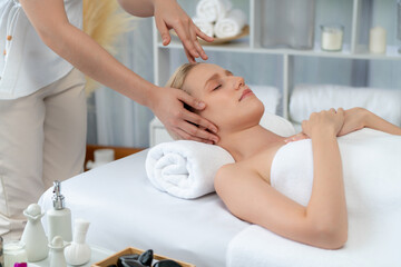 Caucasian woman enjoying relaxing anti-stress head massage and pampering facial beauty skin...