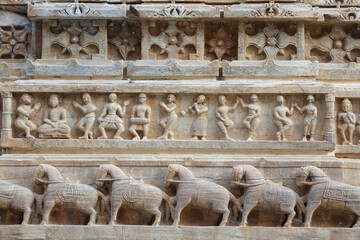 Detail of decorative stone carvings on the walls of the Jagdish Temple in Udaipur, Rajasthan, India. Figures of musicians, dancers and horses.