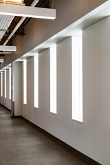 Modern Corridor with Geometric Window Design and Neutral Interior Lighting