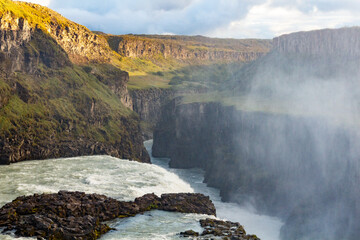 Majestic River Flowing Through a Canyon Surrounded by Mist and Lush Cliffs