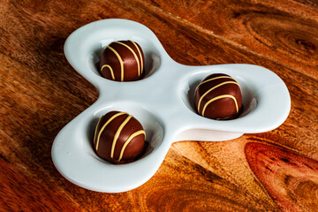 Handcrafted Chocolate Truffles on Artistic Ceramic Platter on Wooden Table