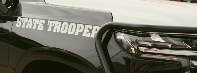 Panorama view black SUV State Trooper patrol vehicle with push bumper steel frames mounted used to push disabled vehicles away from danger or clear roadway ensuring public safety, police bullbars © trongnguyen