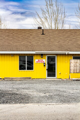 Bright Yellow Site Office Exterior with Signs and Informational Boards