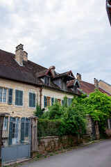 A peaceful and narrow street lined with traditional stone houses in the village of Mouthier-Haute-Pierre, along the Via Francigena in eastern France.