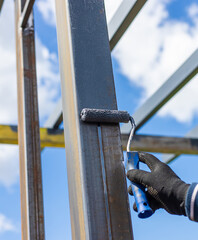 Man painting metal poles. Selective focus.