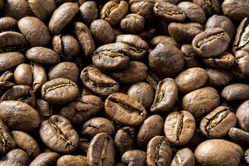 Close-up of roasted Arabica coffee beans , flat lay . Top view of freshly roasted coffee beans . 