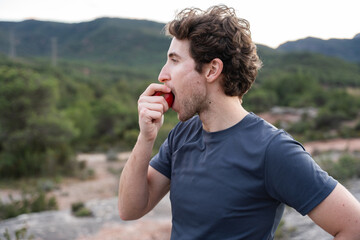 Fitness man eating fruit for balanced nutrition