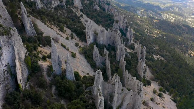 Aerial view of Els Frares. The topography, with its rock formations, casts a striking silhouette. Its striking structures resemble monks turned to stone, in Alicante, Spain.