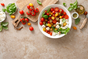 Salad with fresh cherry tomatoes, mozzarella and basil leaves, top view