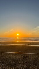 Golden sun dips into tranquil ocean, casting amber hues for coastal Diwali serenity and...