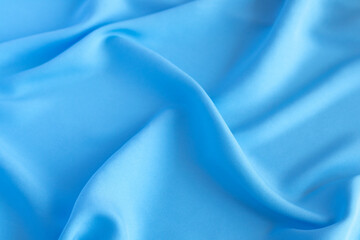 Smooth and flowing blue silk fabric background for elegant designs