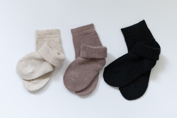 Three pairs of warm socks on a white background, white, brown, black