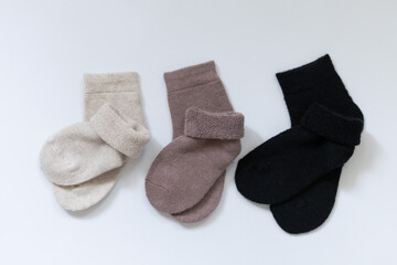 Three pairs of warm socks on a white background, white, brown, black