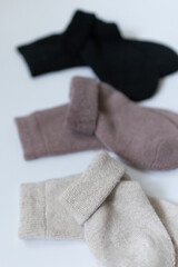 Three pairs of warm socks on a white background, white, brown, black