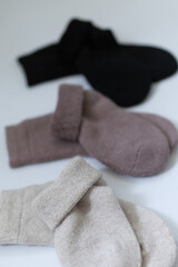 Three pairs of warm socks on a white background, white, brown, black