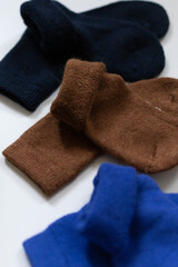 Close-up texture socks three pairs of warm socks on white background blue brown black
