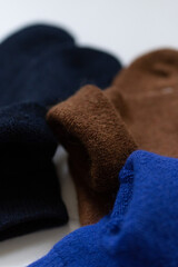 Close-up texture socks three pairs of warm socks on white background blue brown black