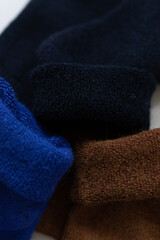 Close-up texture socks three pairs of warm socks on white background blue brown black