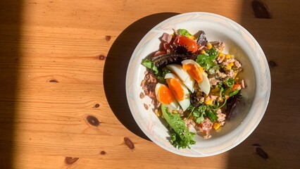 Sunny breakfast tableau with vibrant salad and eggs, evoking brunch indulgence, Earth Day feast,...