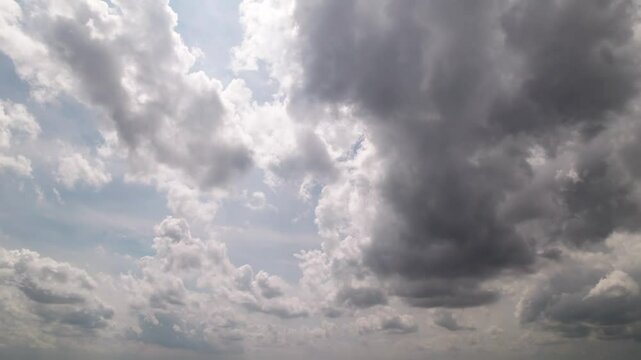 Panoramic view from sky looking and moving towards blue and white fluffy sky and storm precipitation forming before rain with bright sunlight weather leaking through steamy cumulus cloudscape