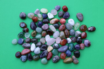 Assorted Polished Gemstones on Green Background
