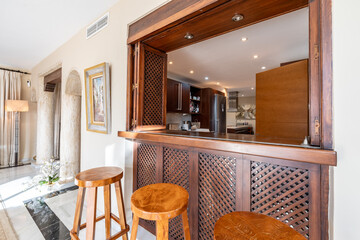 a luxury wooden bar area with stools inside mediterranean real estate 