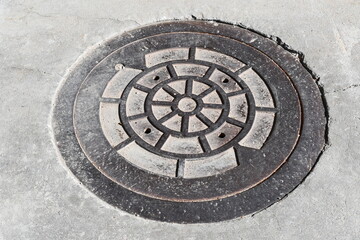 Manhole cover. No markings, fancy design.
