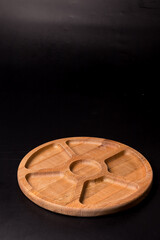 Empty round minazhnitsa made of wood on a black background