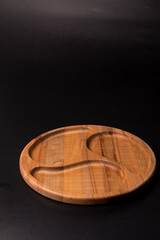 Empty round minazhnitsa made of wood on a black background